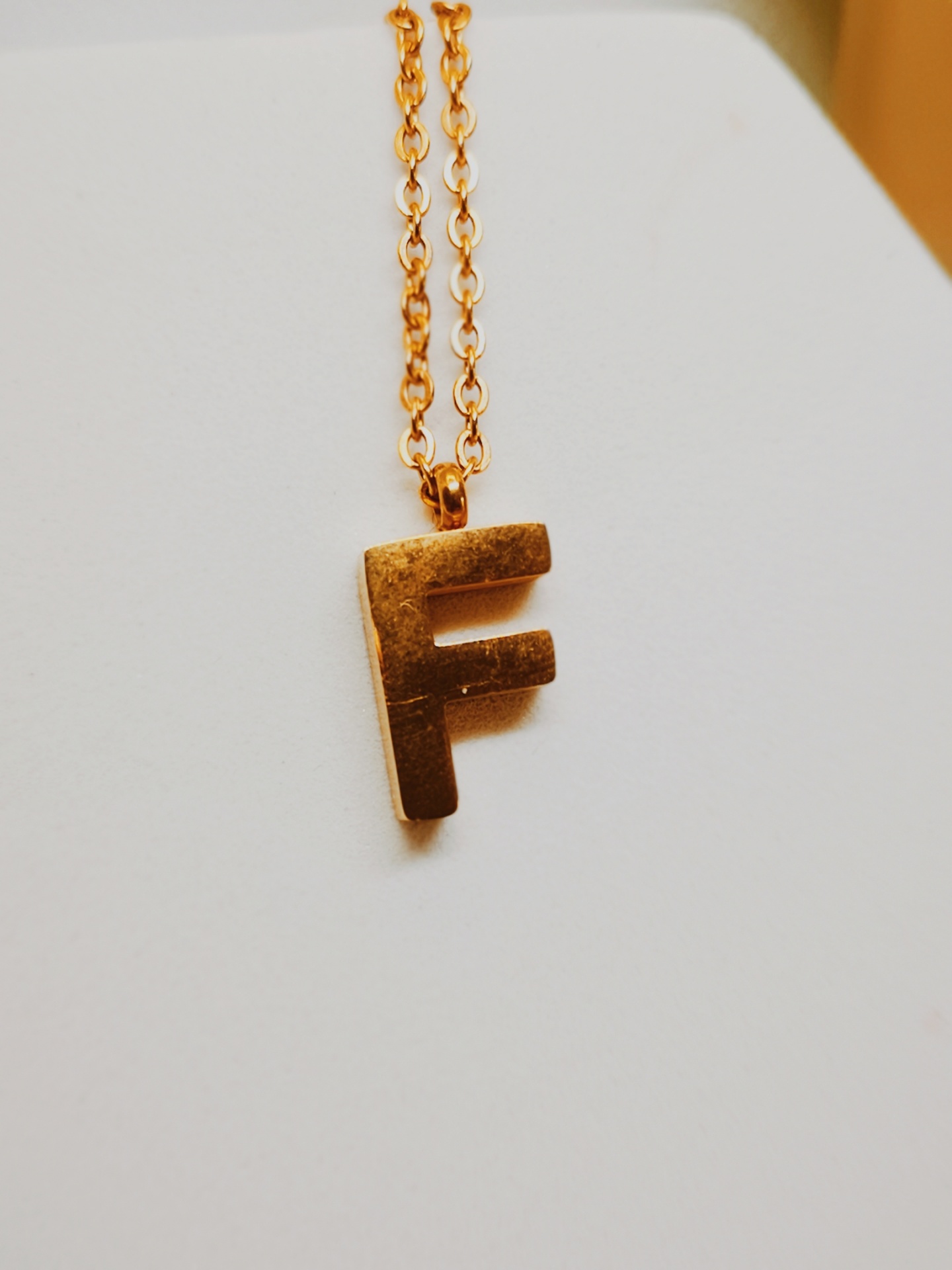 Colar dourado com pendente letra F