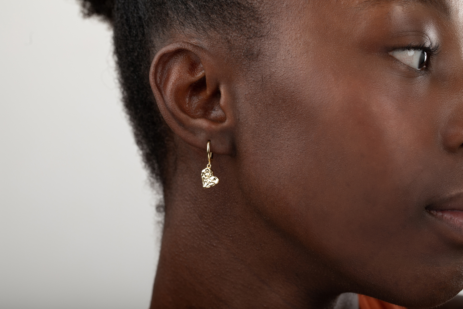 Brinco de argola dourada com pendente em forma de coração texturizado