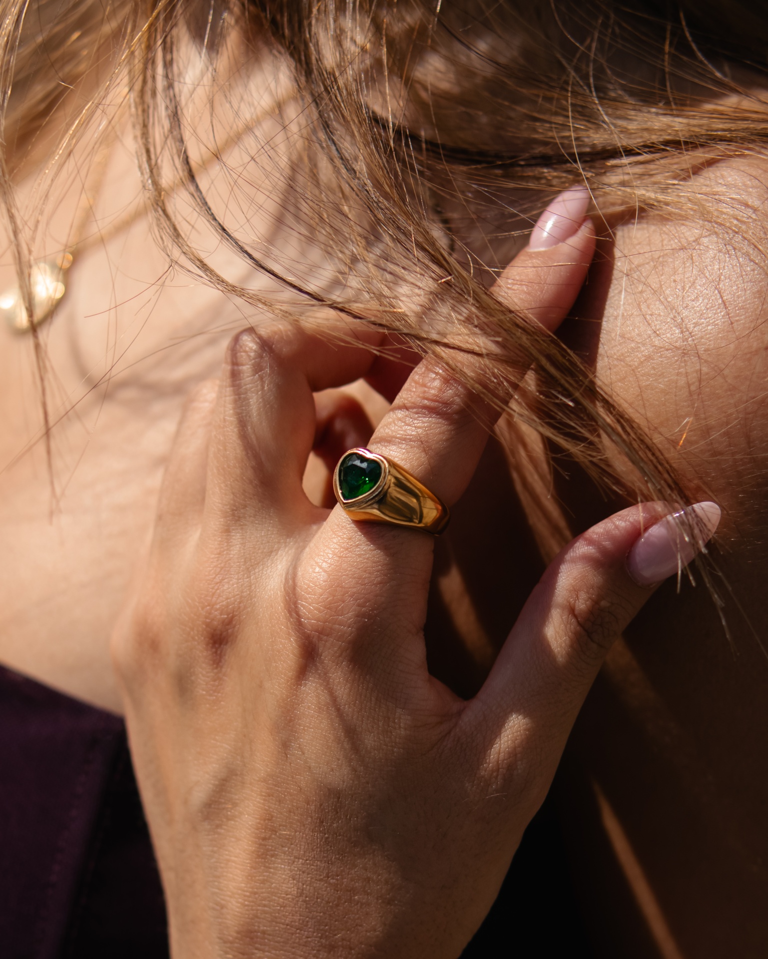 Anel dourado com pedra verde em forma de coração
