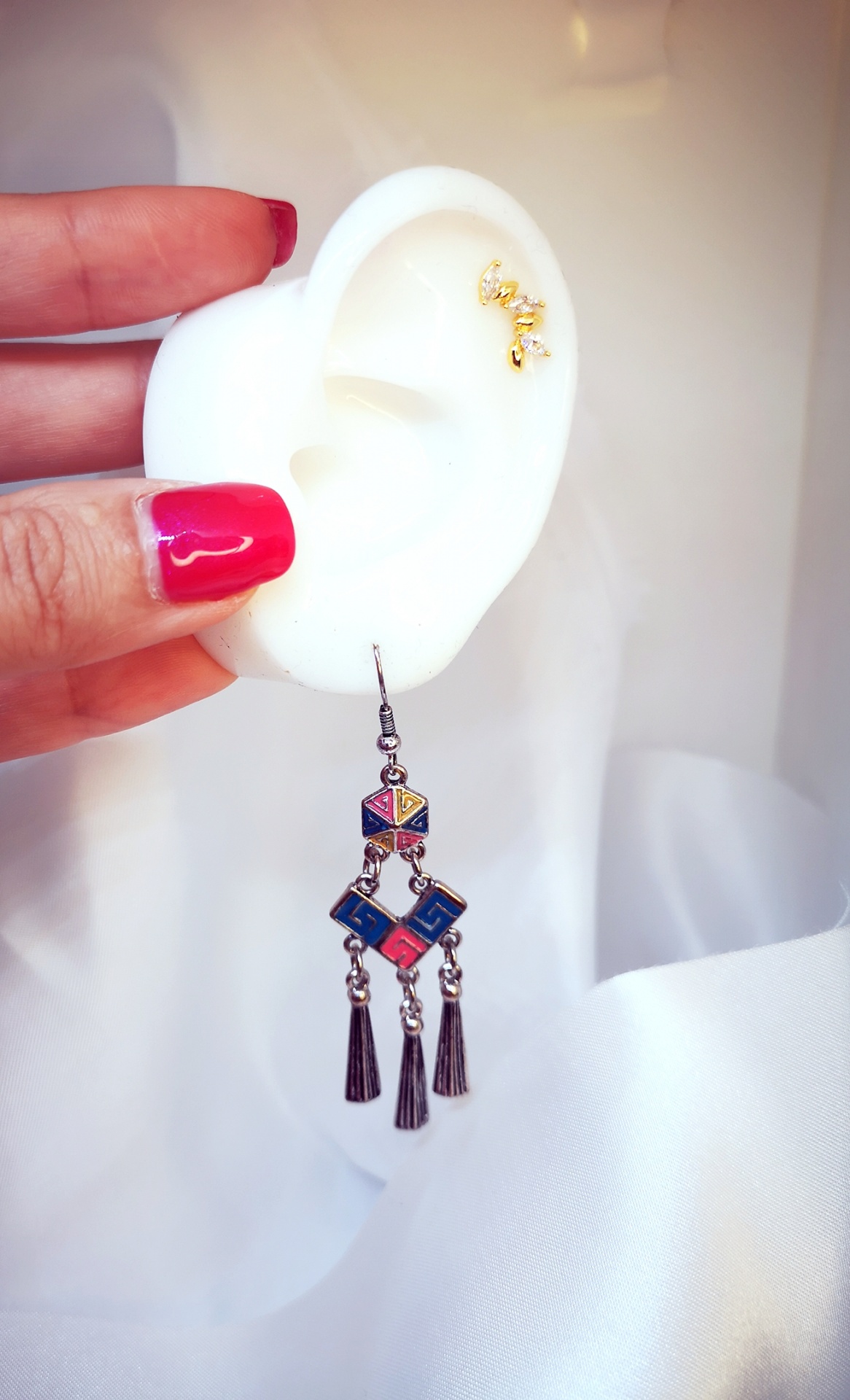 Brinco pendente geométrico colorido num suporte molde de orelha branco