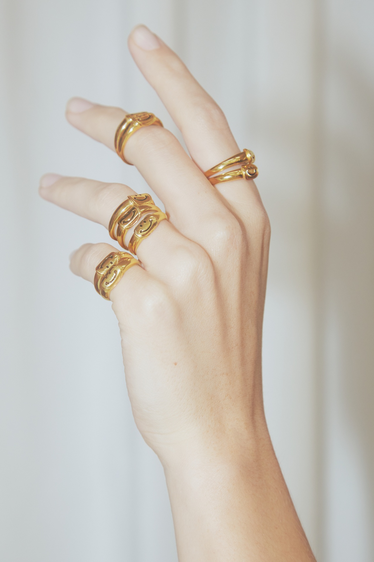 Mão com vários anéis dourados