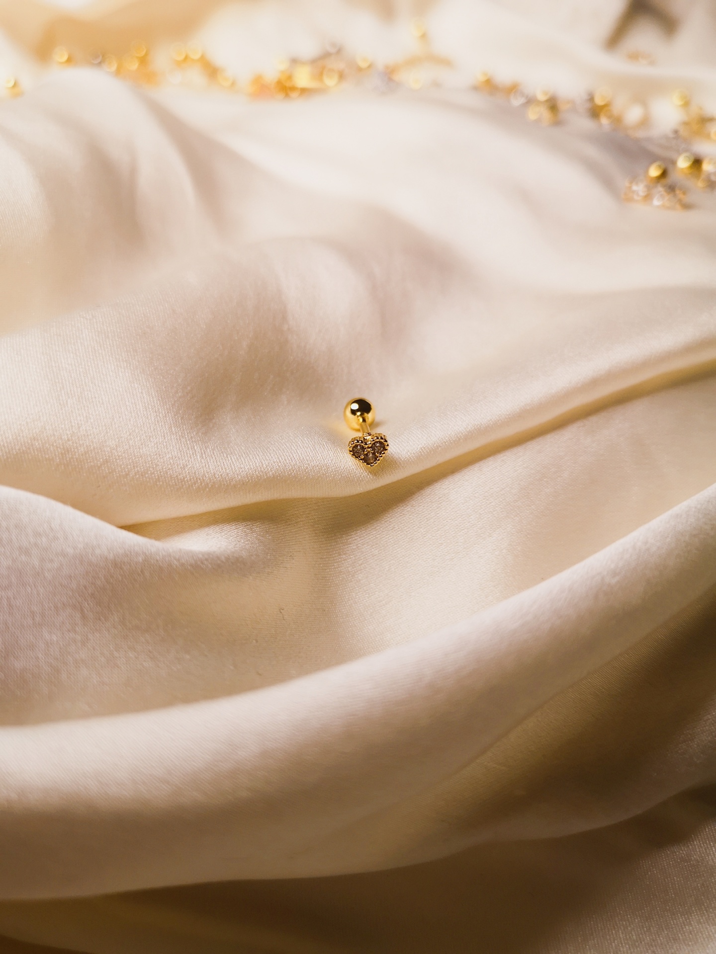 Tecido creme suave com adereço dourado em forma de coração