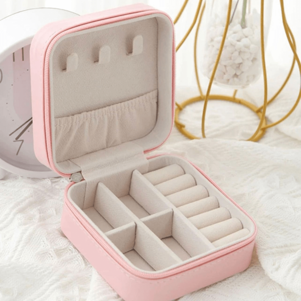 Estojo de joias rosa com interior cinza e vários compartimentos