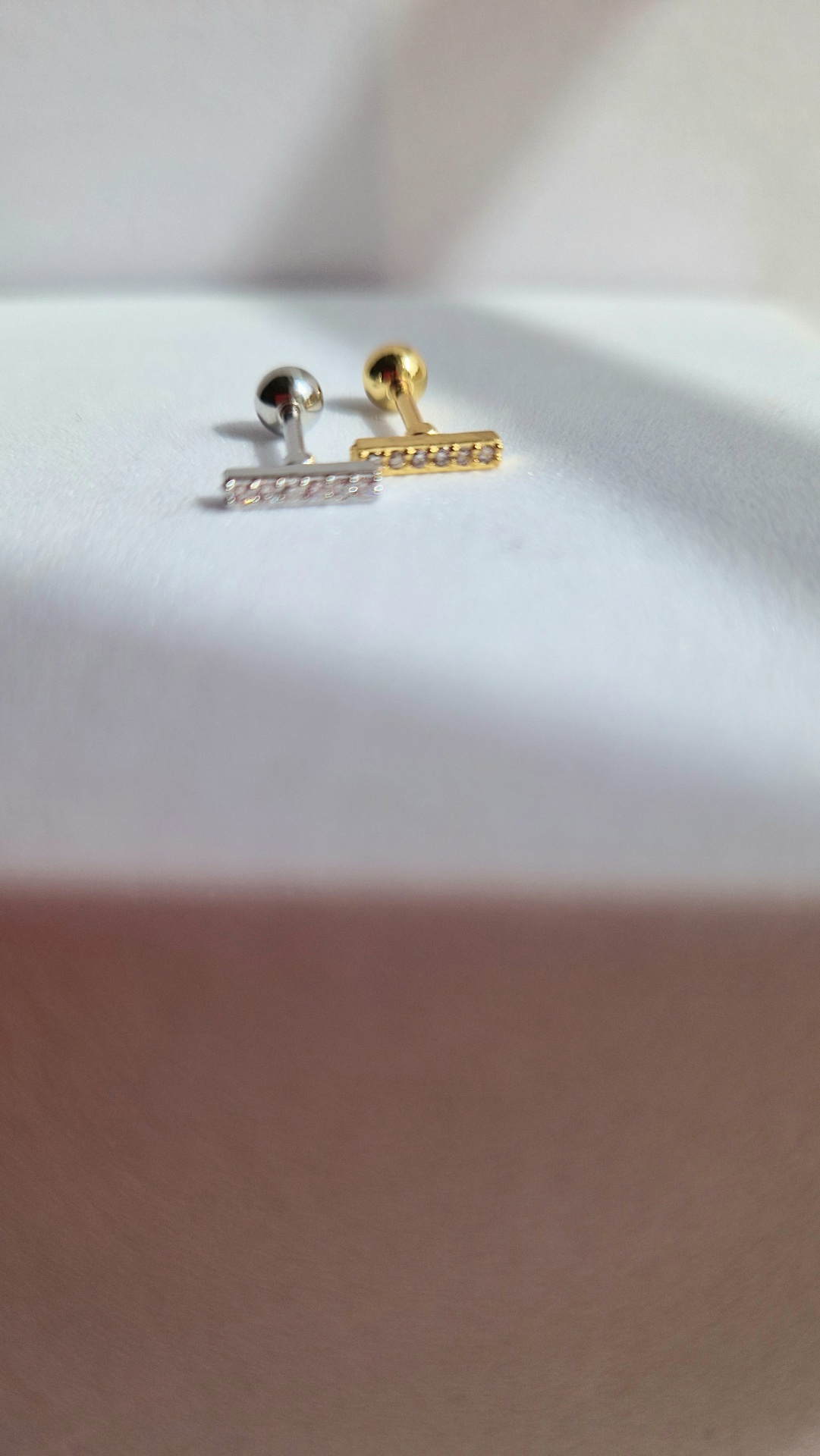 Par de brincos piercing metálicos prateado e dourado com cristais em barra