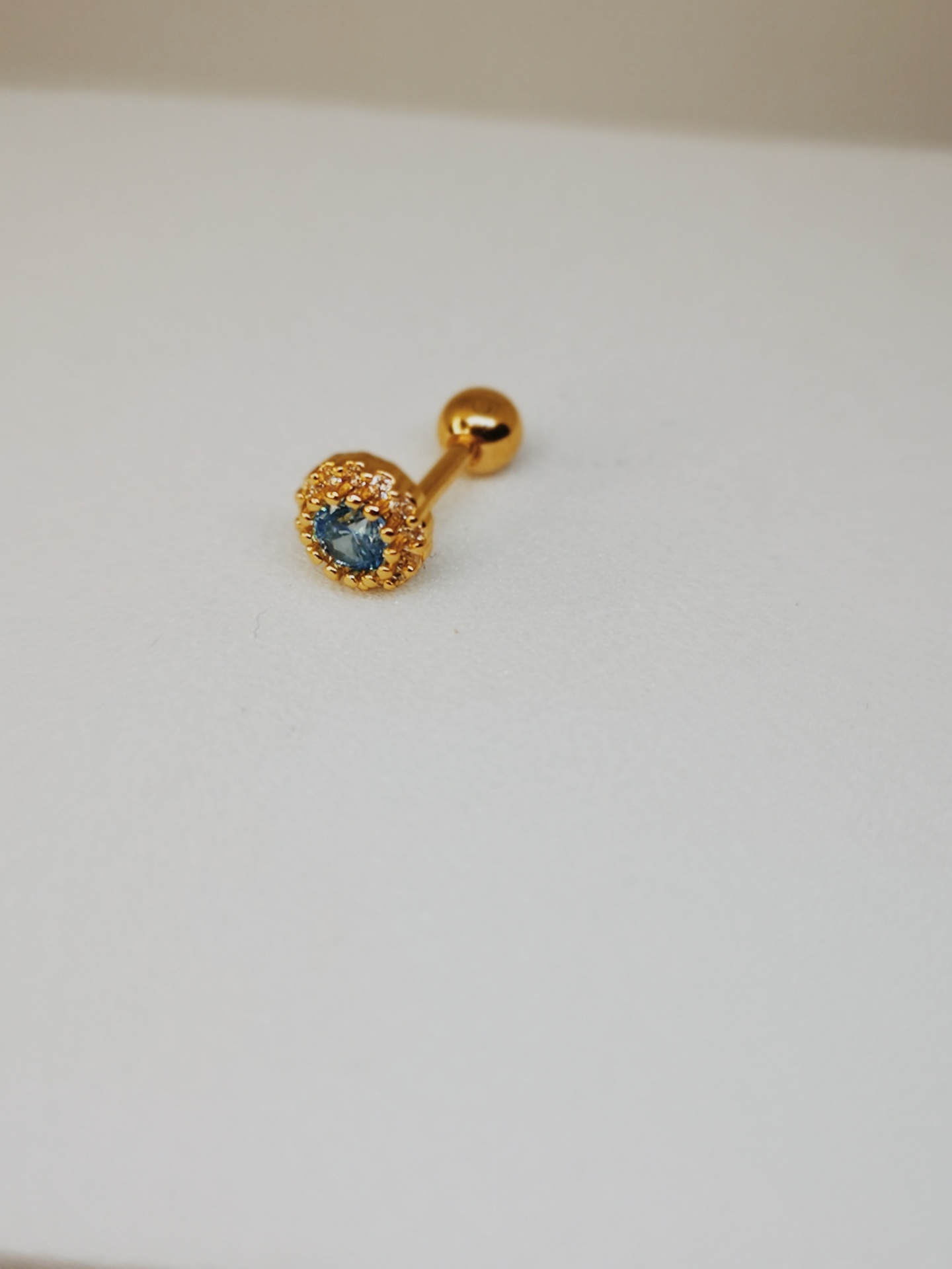 brinco dourado com pedra azul