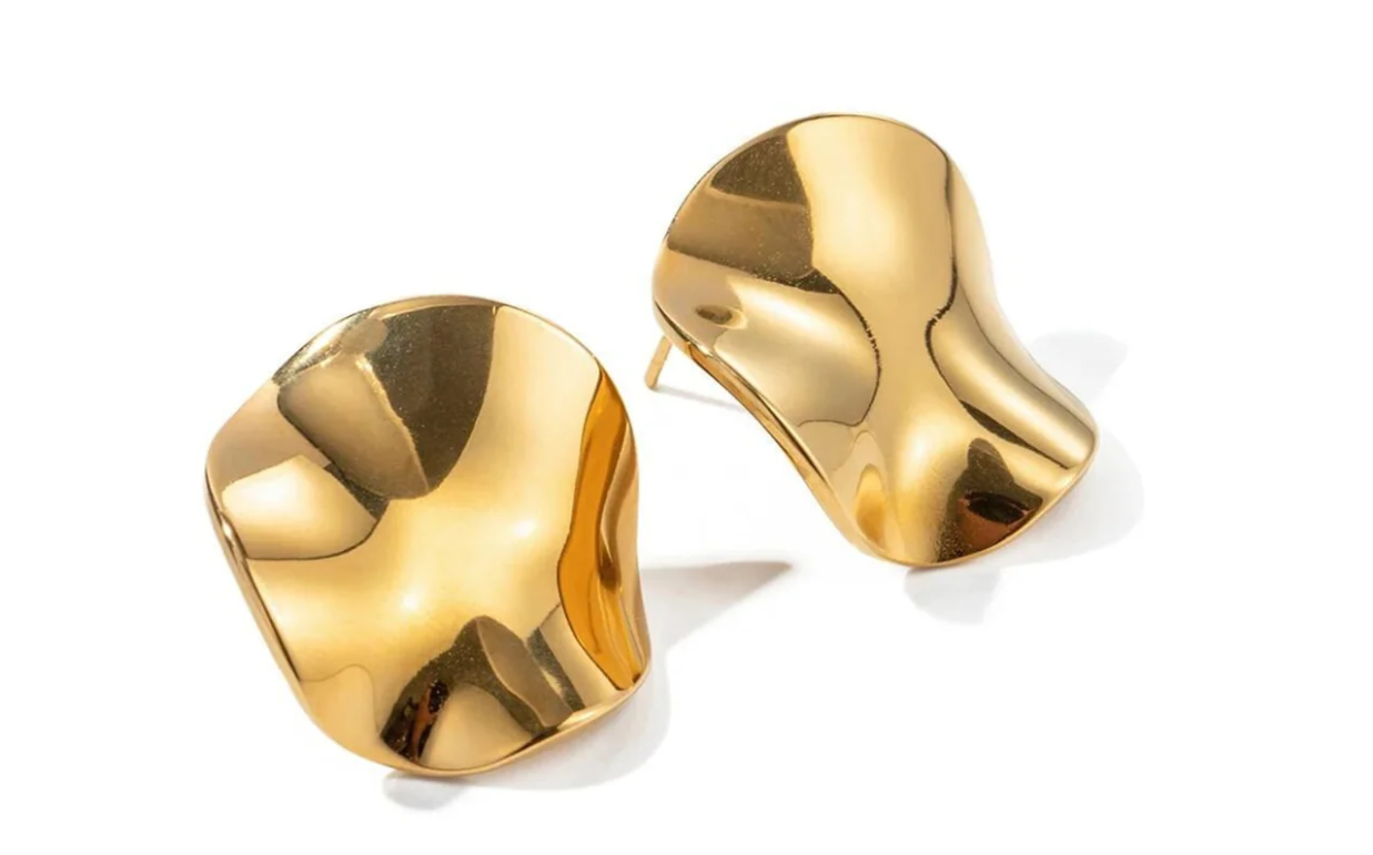 Par de brincos dourados ondulados em fundo branco