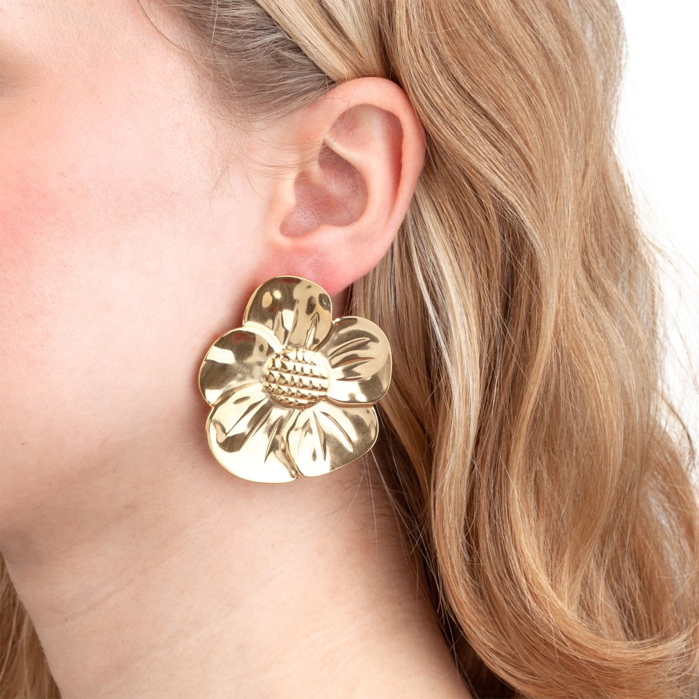 Brinco dourado em forma de flor grande na orelha