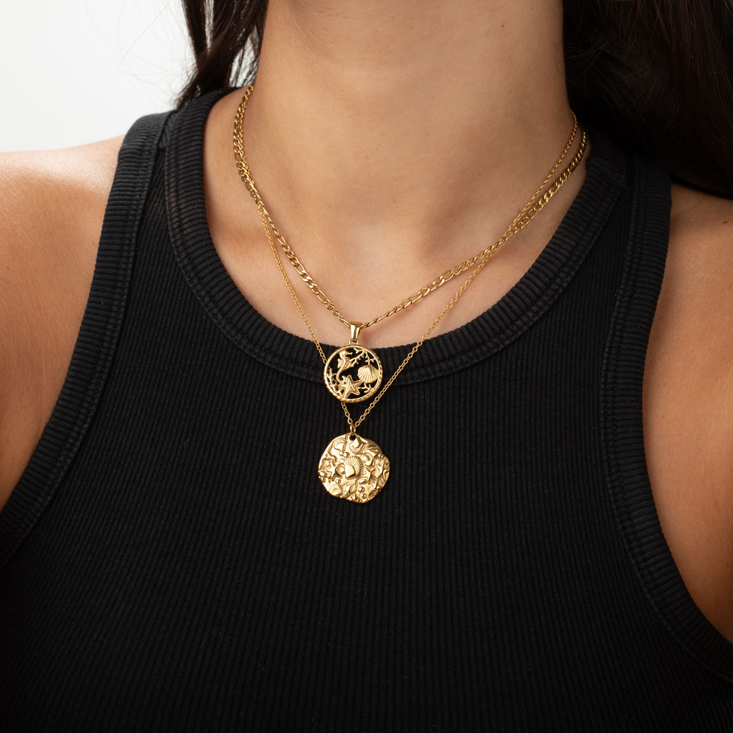 Colar dourado com dois pendentes redondos usados com camisola preta