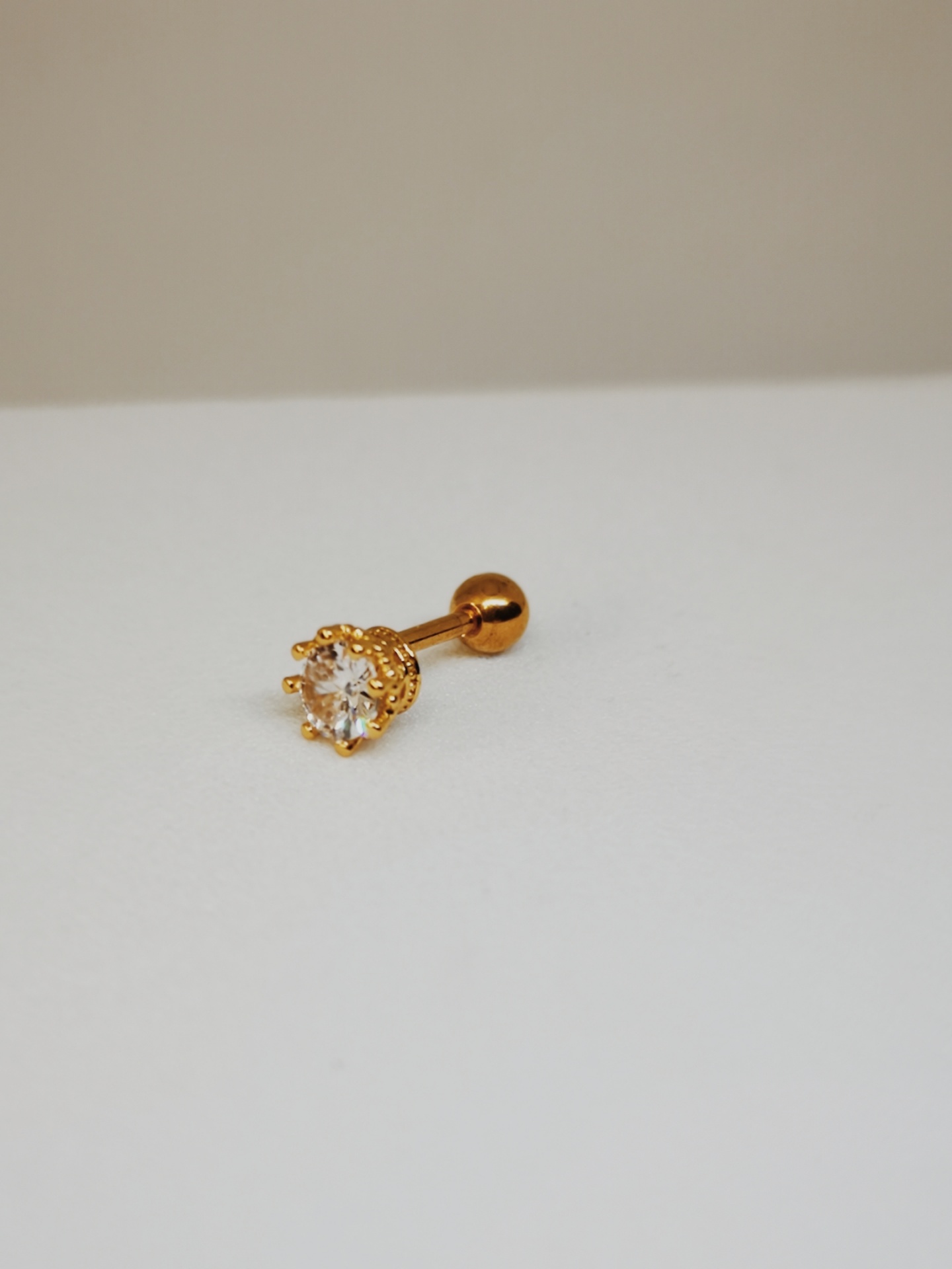 Brinco dourado com pedra transparente redonda