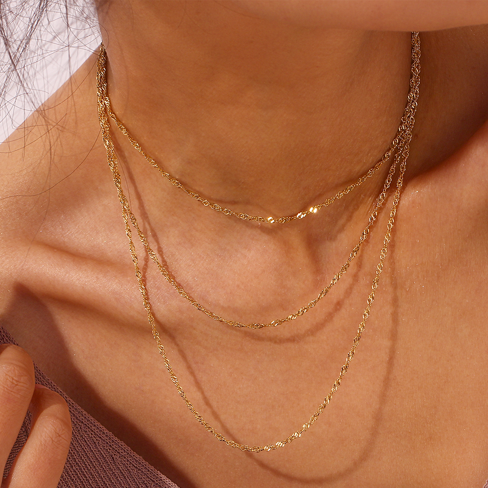 Colar triplo dourado em pescoço feminino