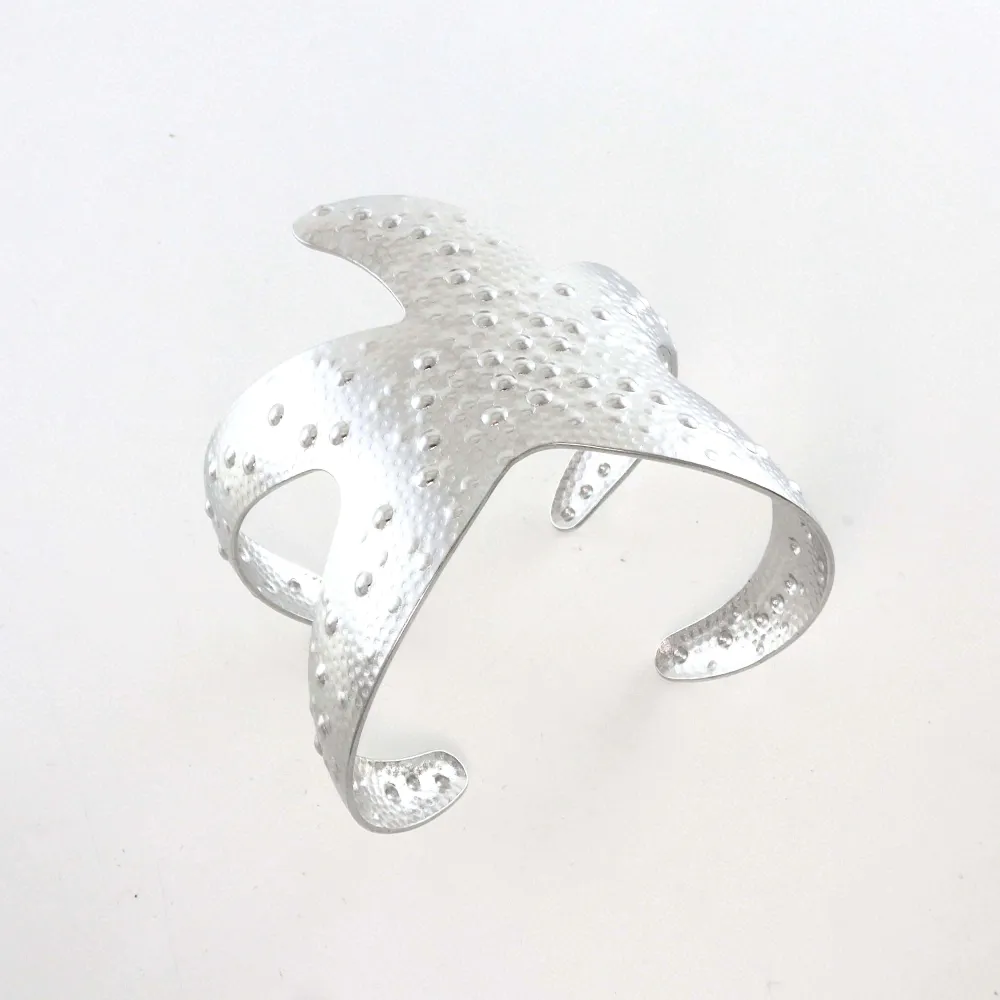 Pulseira em metal prateado com pontos elevados