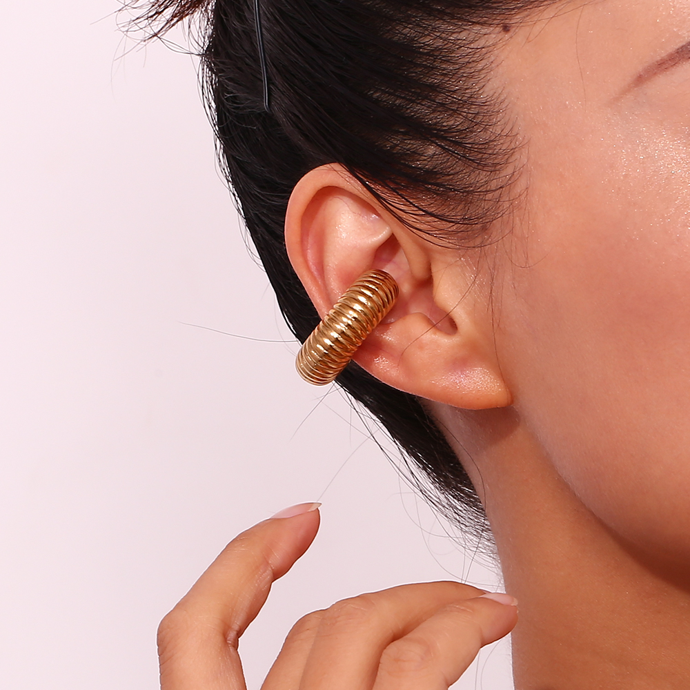 Brinco dourado em espiral grosso na orelha esquerda
