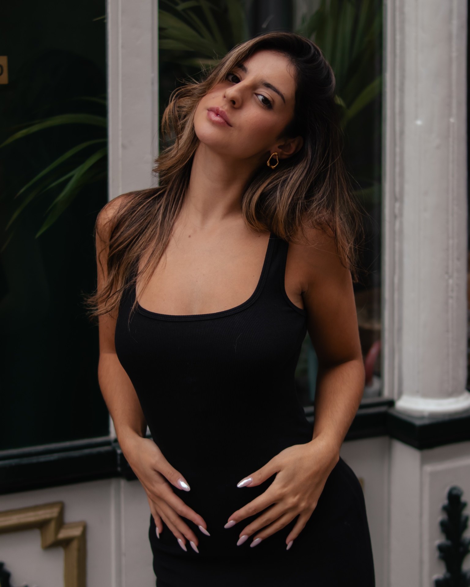 Mulher com vestido preto justo de alças largas em ambiente urbano