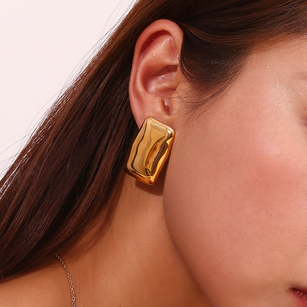 Brinco dourado retangular com textura ondulada norelha