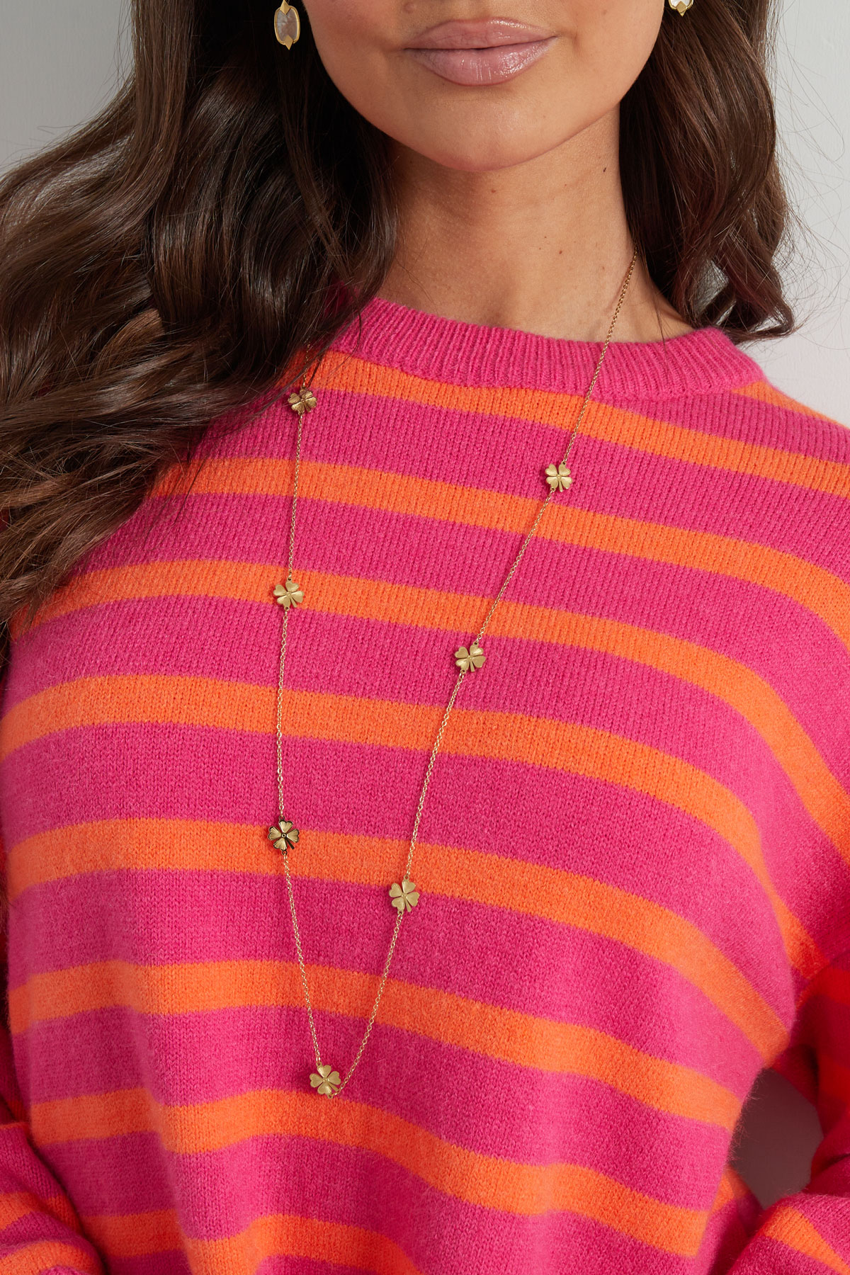 Camisola de malha riscada cor-de-rosa e laranja com colar dourado de flores