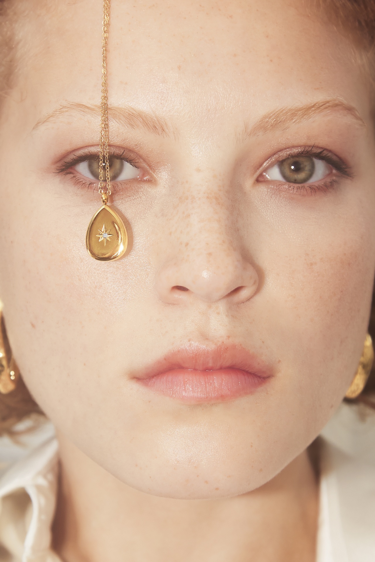 Mulher com colar dourado com pendente em forma de gota com estrela