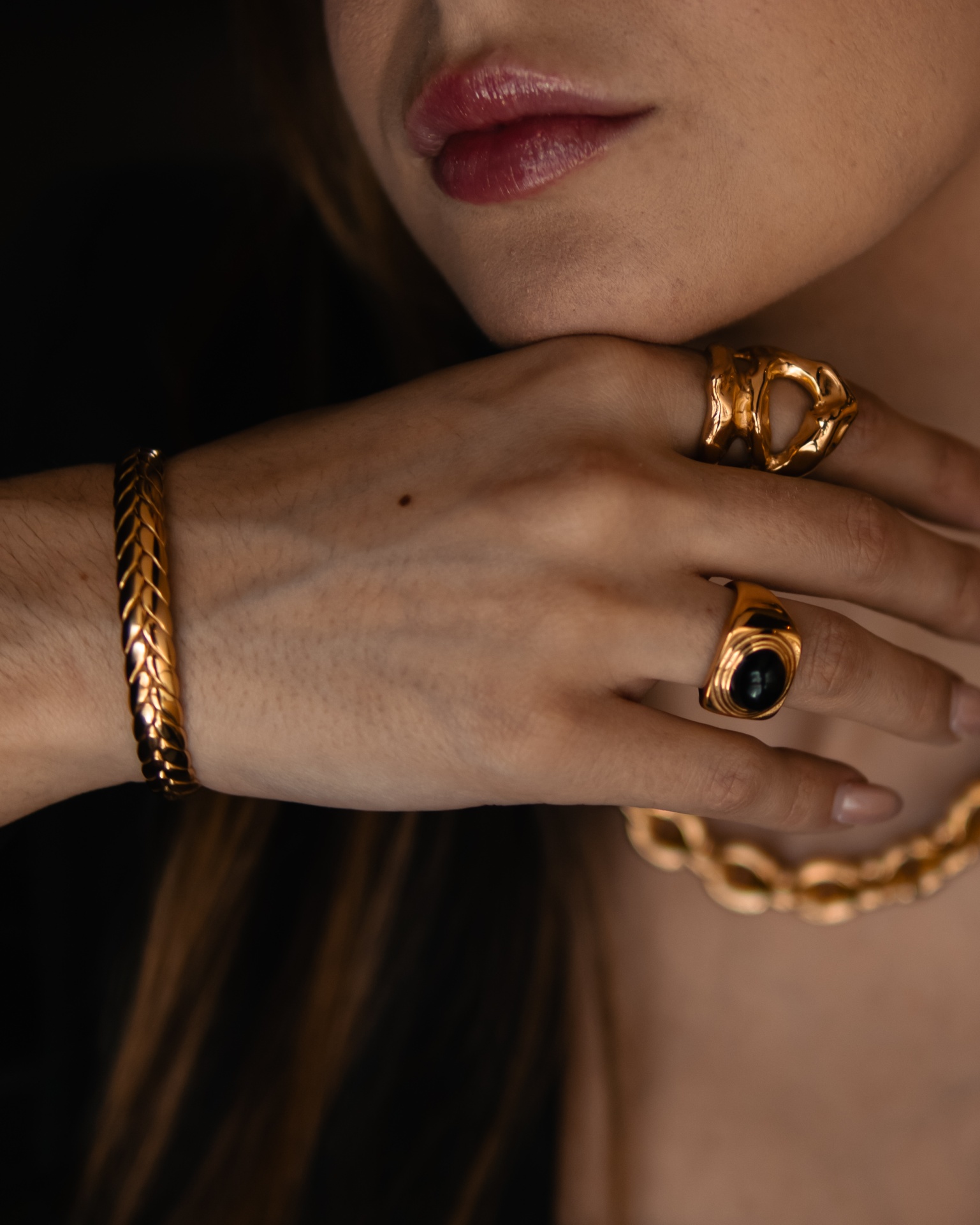 Mulher com joias douradas e lábios vermelhos