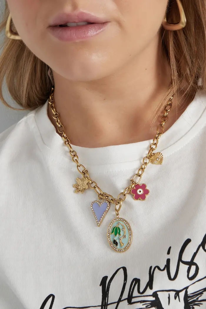 Colar dourado com pendentes coloridos em mulher com camisola branca