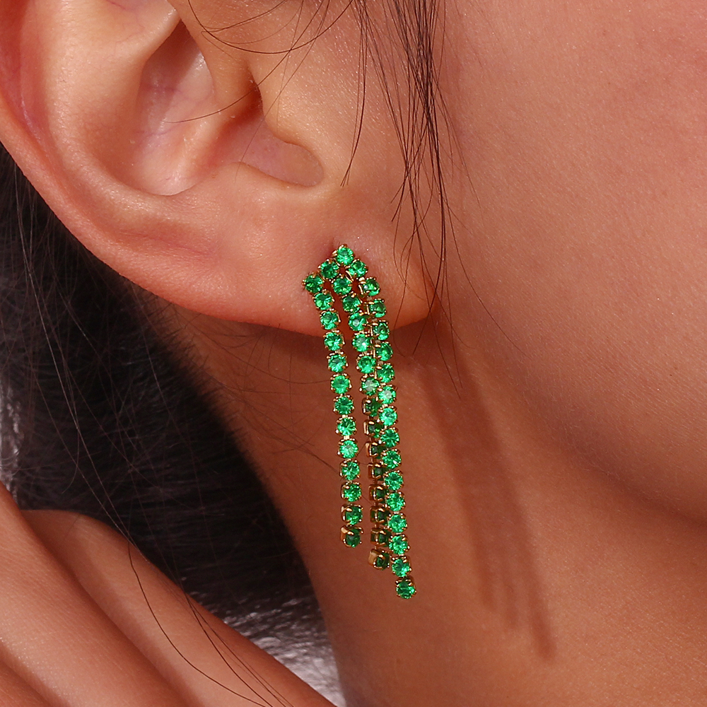 Brinco pendente com cristais verdes em orelha feminina