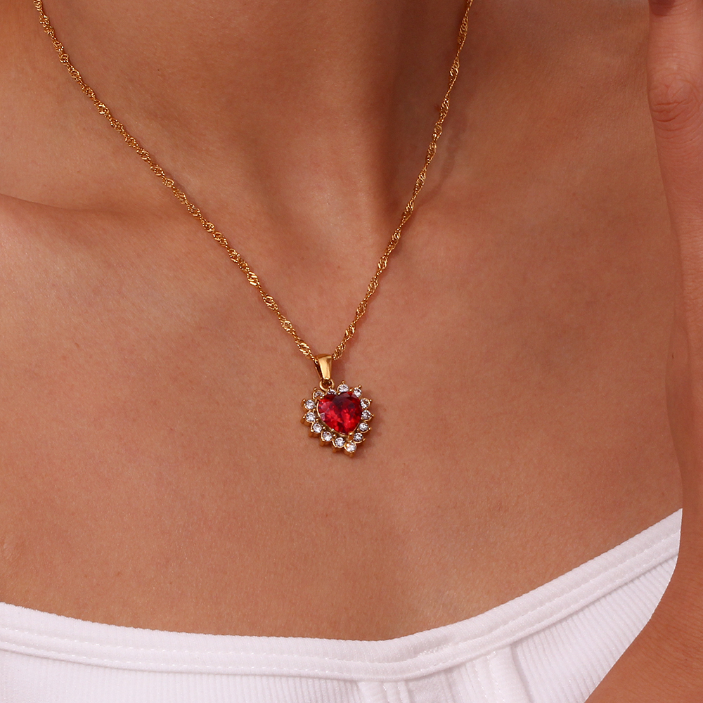 Colar dourado com pendente em forma de coração vermelho com pedras brancas