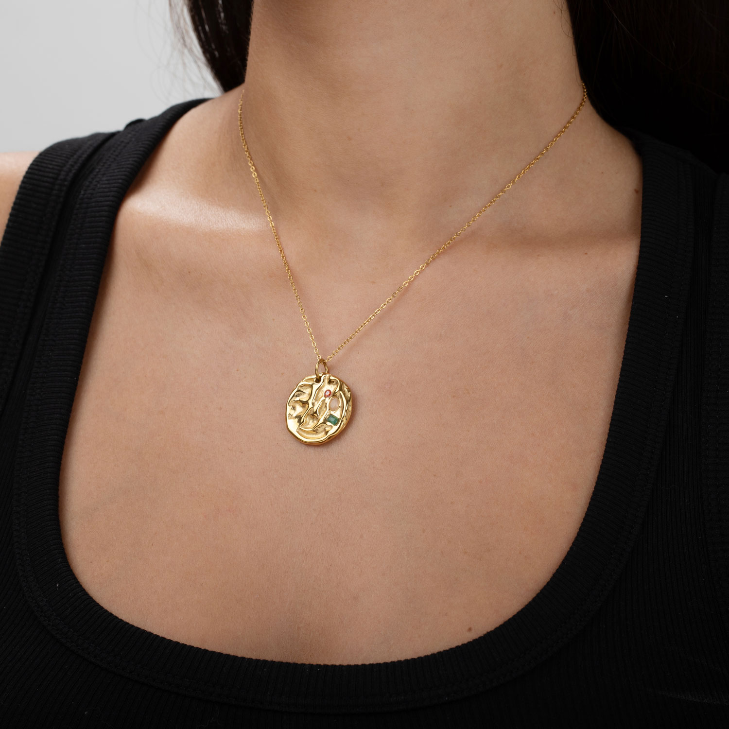Colar dourado com pendente redondo decorado com pedras vermelha e verde