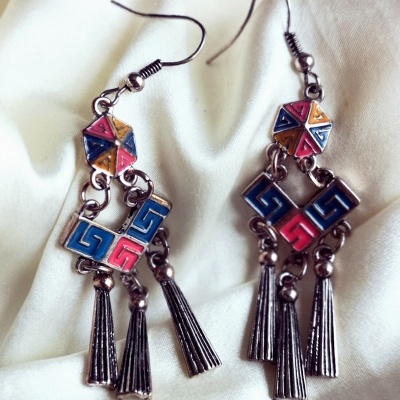 Brincos metálicos pendentes com padrões geométricos coloridos e franjas