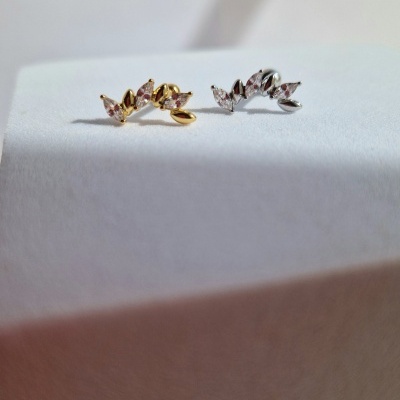 Dois brincos pequenos com pedras rosa sobre superfície branca