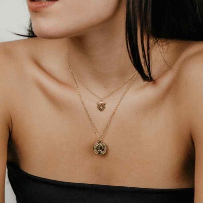 Colar duplo dourado com pendentes redondos usados por mulher