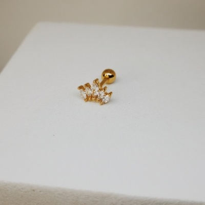 Brinco dourado com pedras cristal sobre superfície branca