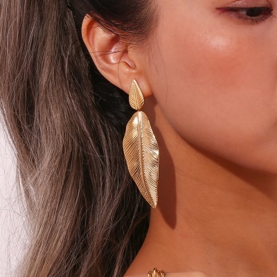 Brincos dourados formato folhas com textura detalhada