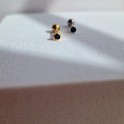 Dois brincos pequenos, dourado e prateado, com pedra preta circular