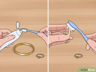 Mãos a escovar uma joia dourada com uma escova de dentes azul e pasta de dentes numa superfície de madeira.