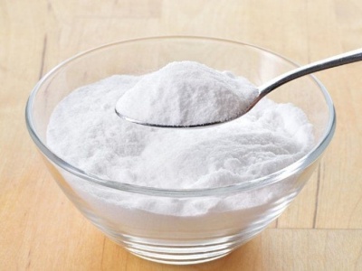 Taça de vidro transparente com pó branco e colher com pó branco