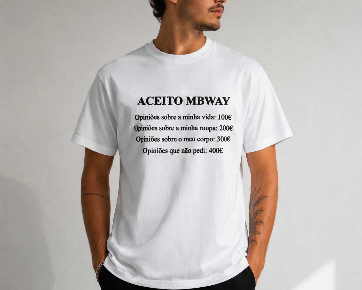 T-shirt branca com texto a preto e homem com tatuagens no braço
