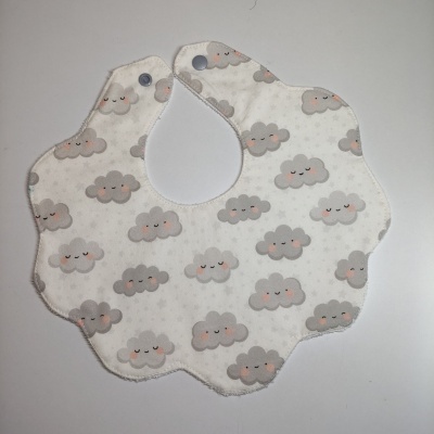 Babete para bebé em algodão com padrão de nuvens sorridentes em fundo branco