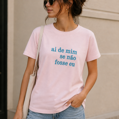 Mulher com t-shirt rosa e óculos escuros em ambiente urbano.