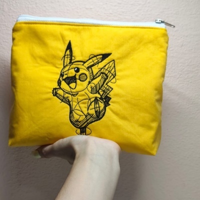 Estojo amarelo de tecido com bordado de Pikachu e fecho branco