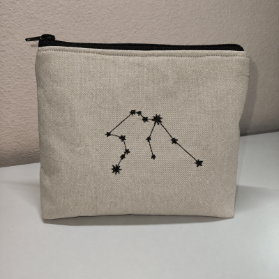 Necessaire bege com bordado preto de constelação e fecho preto
