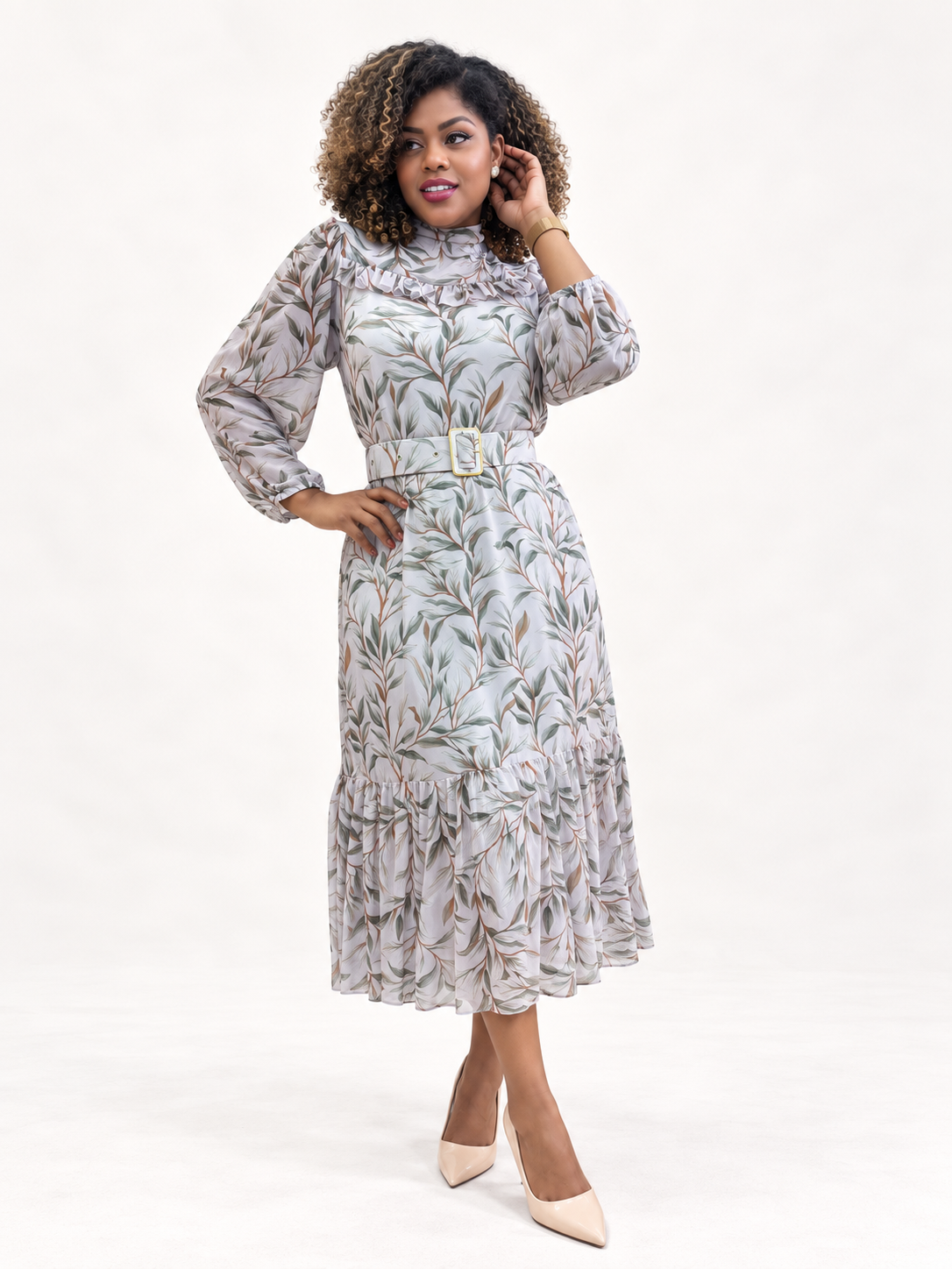 Vestido comprido com padrão de folhas verdes e castanhas com cinto branco e sapatos nude