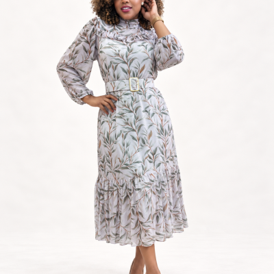 Vestido comprido com padrão de folhas verdes e castanhas com cinto branco e sapatos nude