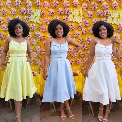 Três mulheres com vestidos amarelo, azul claro e branco em fundo amarelo com flores rosas