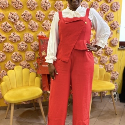 Macacão vermelho feminino com blusa branca de laço e punhos com flores