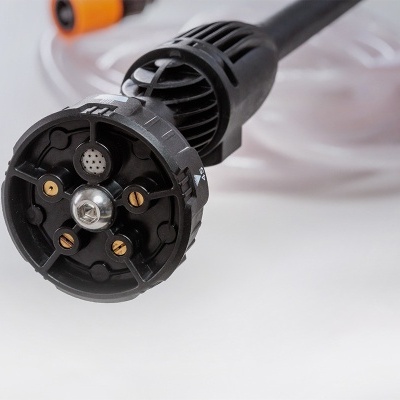 Bico de aspersor preto com orifícios e mangueira transparente ao fundo