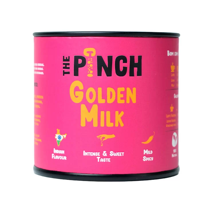 The Pinch Golden Milk Condimento Lata rosa de the pinch golden milk com texto e gráficos relacionados ao sabor.