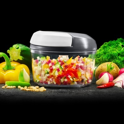 Picador manual com legumes picados e vegetais frescos ao redor