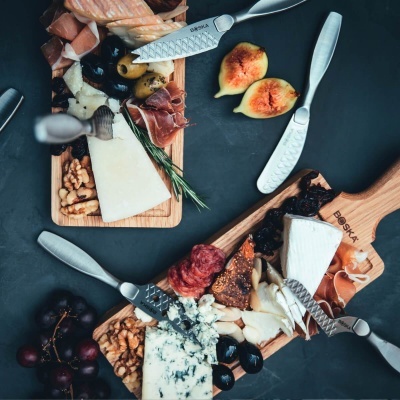 Tábuas de queijos, enchidos, frutas e nozes com facas