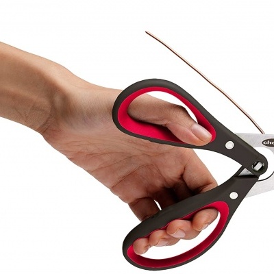 Tesouras multifunções com punhos pretos e vermelhos seguradas por uma mão