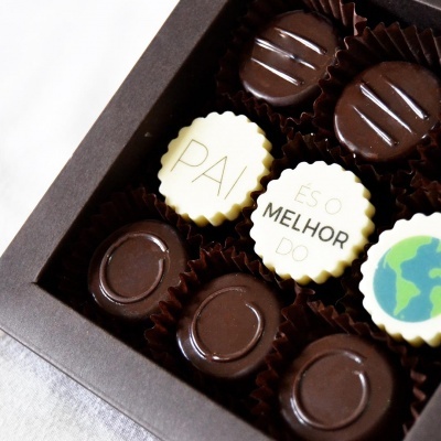 Caixa de bombons com chocolates escuros e brancos decorados com textos e imagem do globo