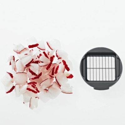 Cortador de legumes quadrado e pedaços cortados de legumes brancos com riscas vermelhas