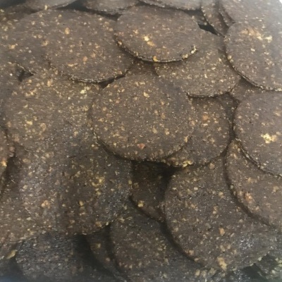 Bolachas redondas castanho escuro com manchas claras num recipiente